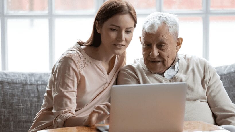 older man with younger woman looking at computer applying for tanf