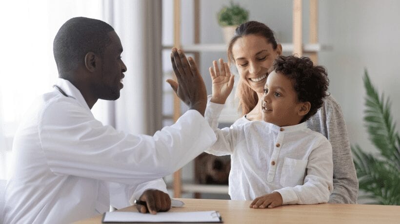 doctor high fiving child with mother health programs