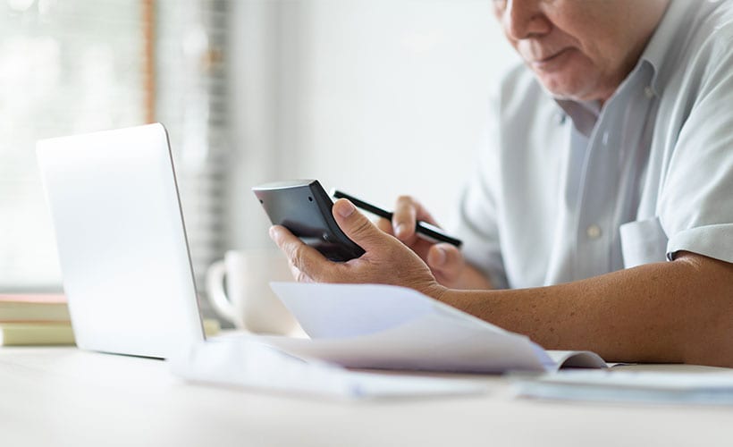 senior man computer calculator and papers ssi benefit payments