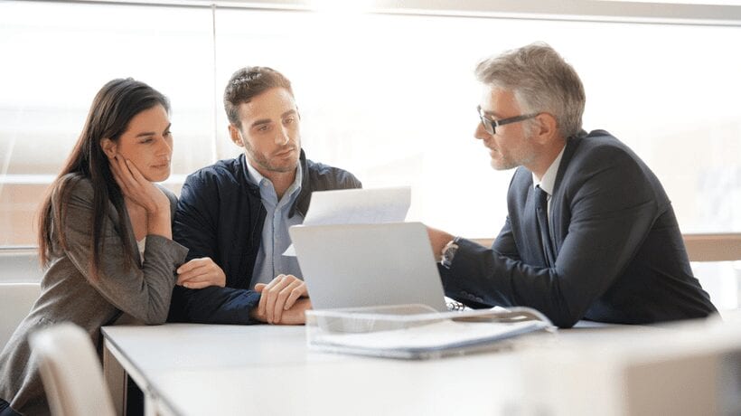 couple discussing paperwork with man housing counseling